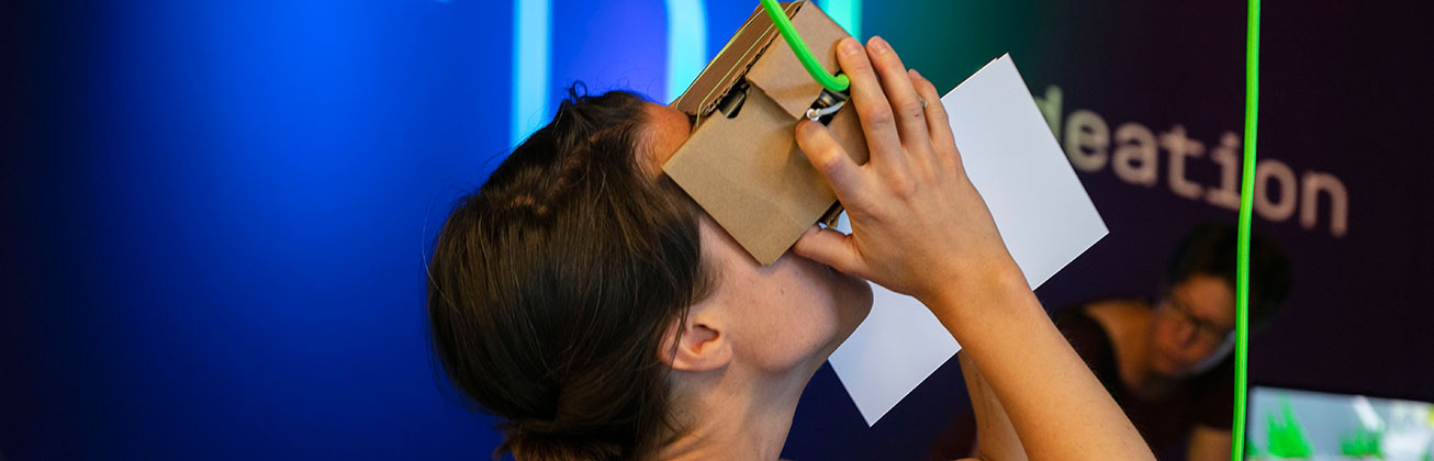Person testet eine VR-Brille am Messestand von Digital Ideation