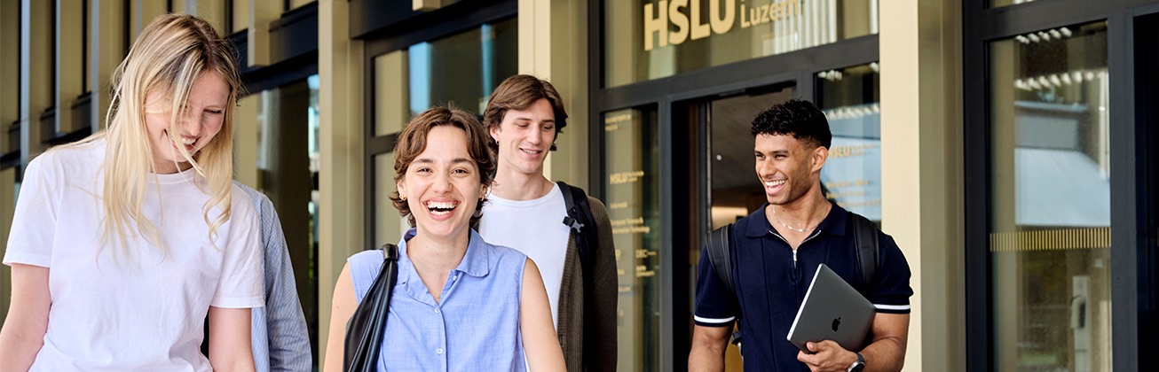 Lachende Studierende vor dem Haupteingang des Campus Zug-Rotkreuz