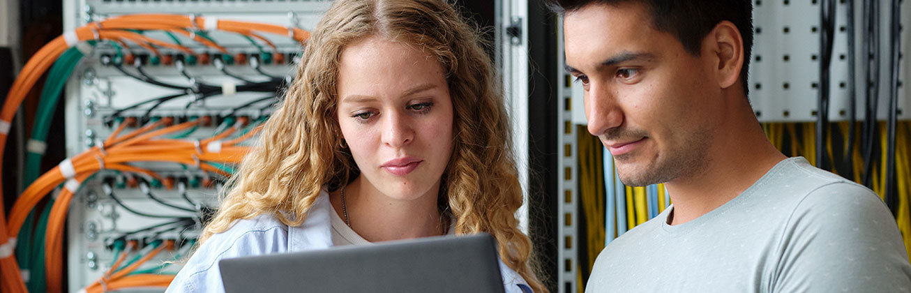 Eine Frau und ein Mann schauen in einen Computer