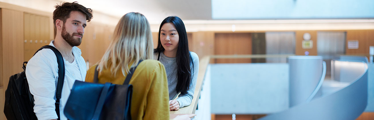 Drei Studierende sprechen zusammen