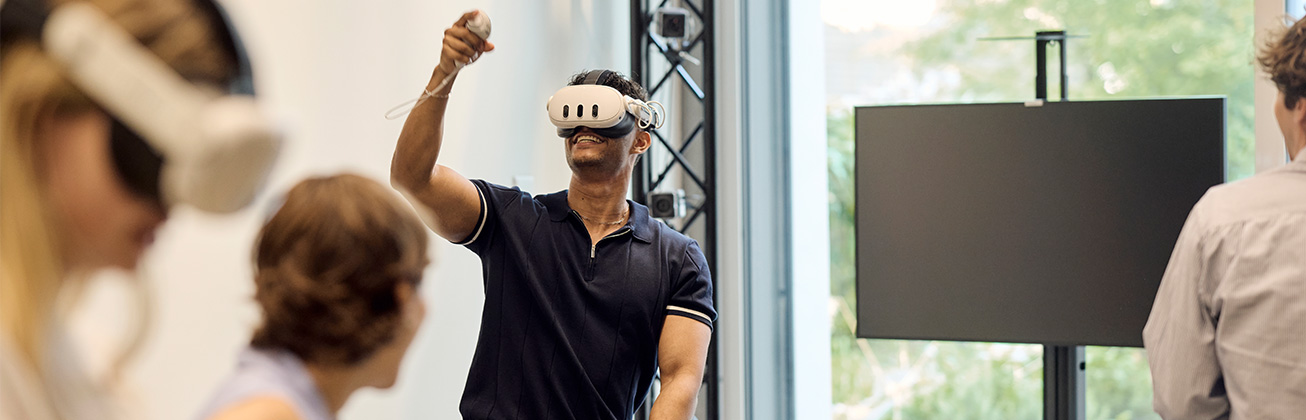 Ein lachender Student trägt eine VR-Brille