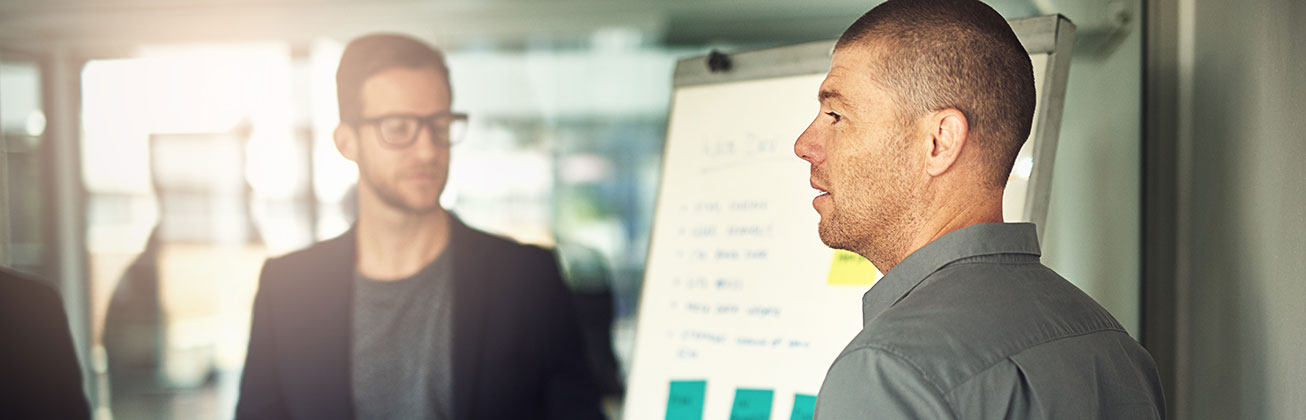 Zwei Männer vor einem Flipchart