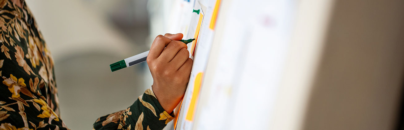 Hand schreibt auf Tafel