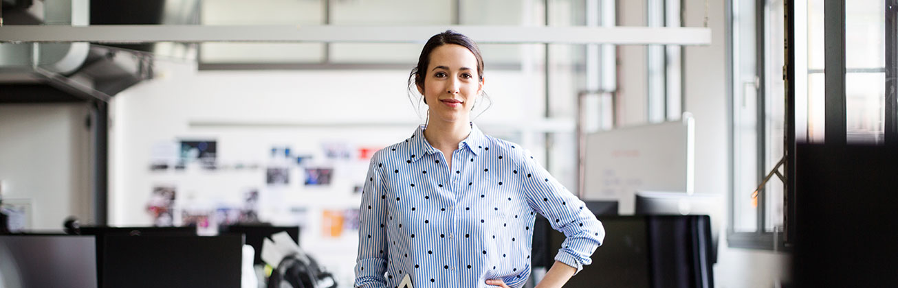 selbstbewusste Frau steht im Büro