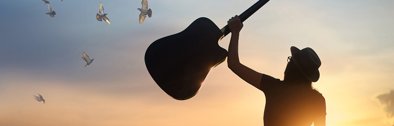 Mensch hält Gitarre in die Luft