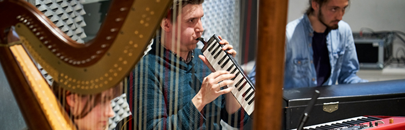 Studierende improvisieren am Piano, an der Harfe und am Harmonium