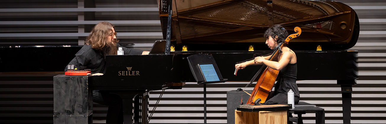Zwei Personen auf der Bühne am Musizieren, die eine am Klavier, die andere spielt Cello