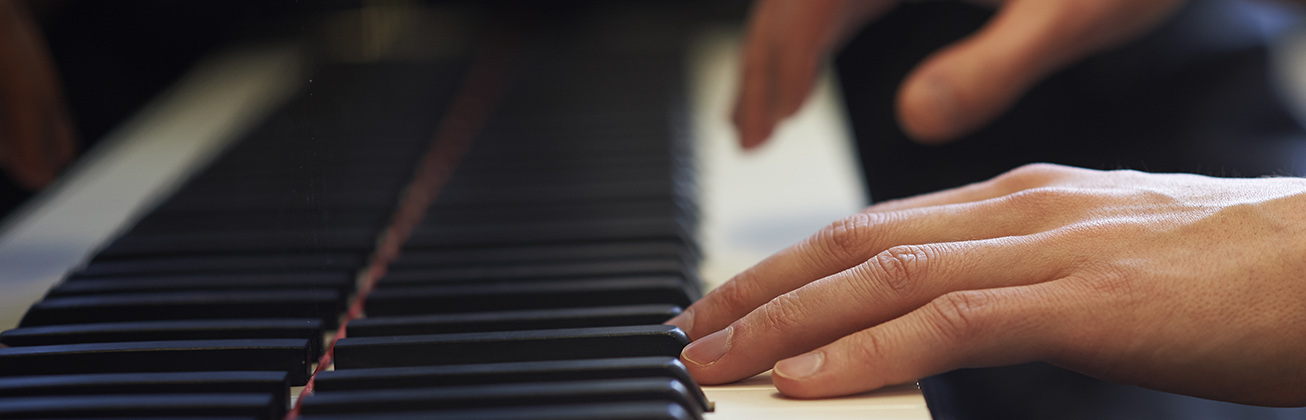 Hände auf einer Klaviertastatur