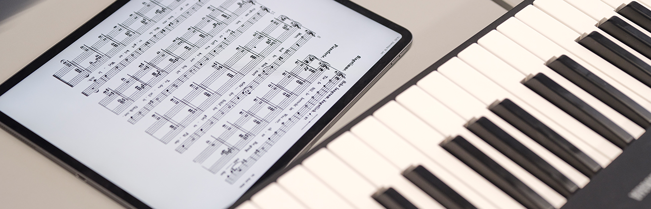 Musiktheorie auf einem Tablet lernen vor einem Keyboard