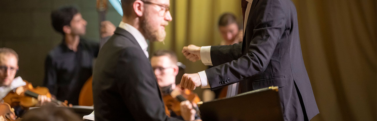 Ein Student (Master Dirigieren) leitet ein Konzert mit dem Akademiechor, Solisten und der Jungen Philharmonie Zentralschweiz. Bild HSLU/Priska Ketterer