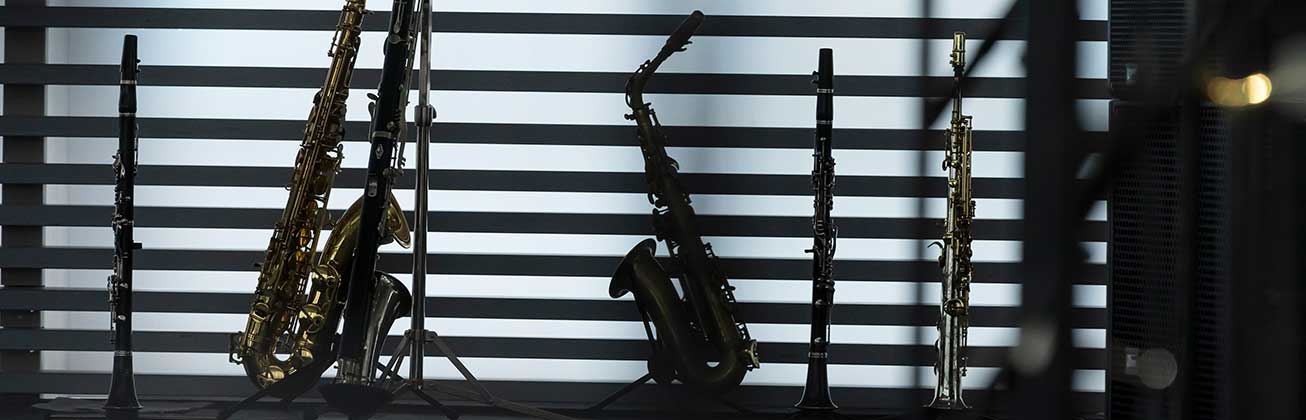 Blasinstrumente von Jazz-Studierenden auf der Bühne im Gegenlicht.