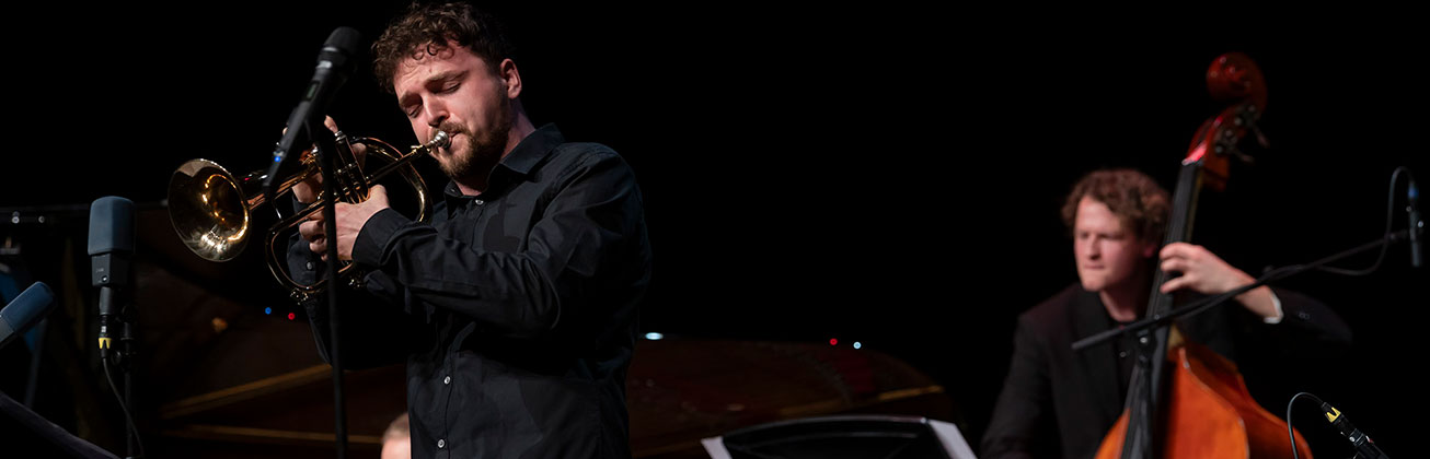 Jazz-Trompeter und Kontrabassist spielen live auf der Bühne bei einem Konzert der Hochschule Luzern.