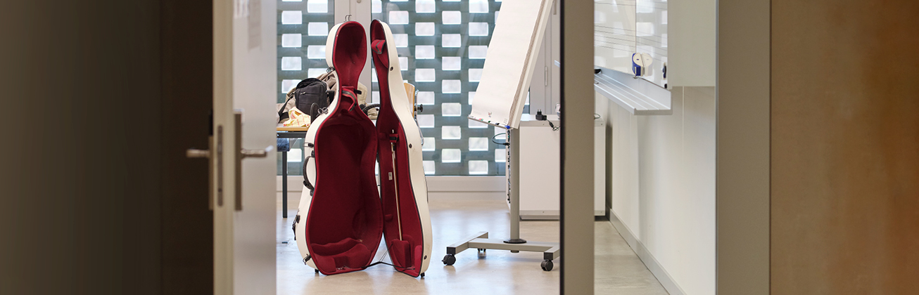 offener Cellokoffer in einem Schulzimmer vor der Tafel