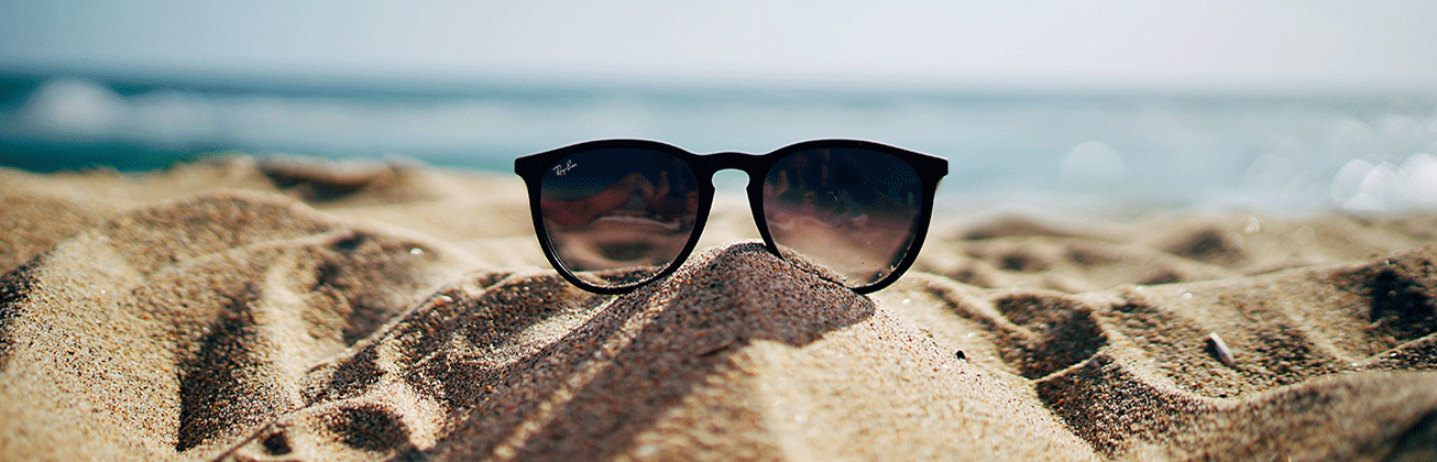 Sonnenbrille im Sand