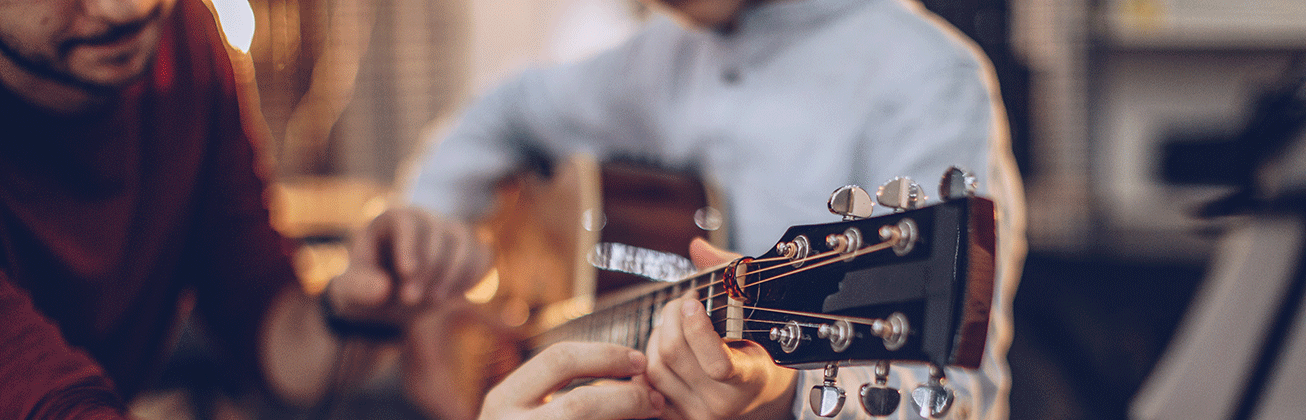 zwei Menschen an Gitarre
