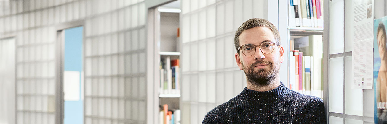 Der Sozialarbeit-Student Samuel Graf vor Bücherregalen