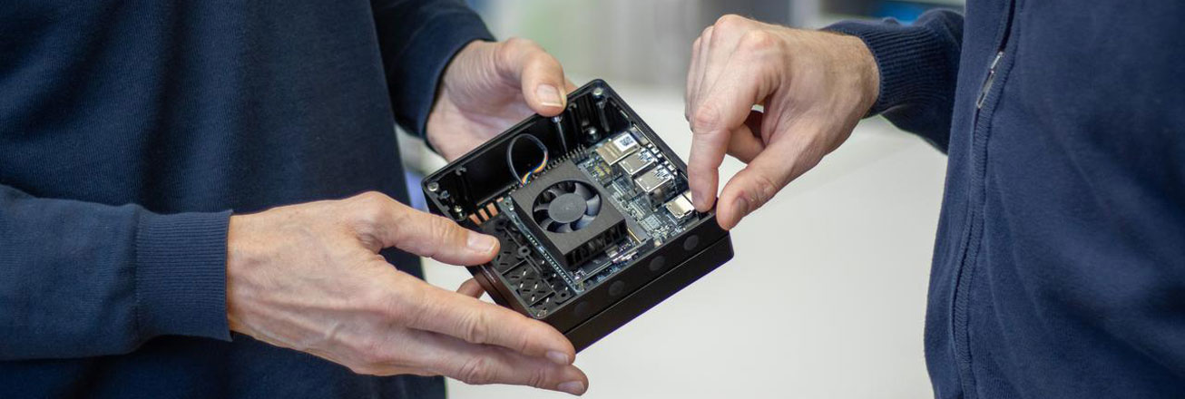 Zwei Forschende betrachten einen Prozessor für KI-Anwendungen