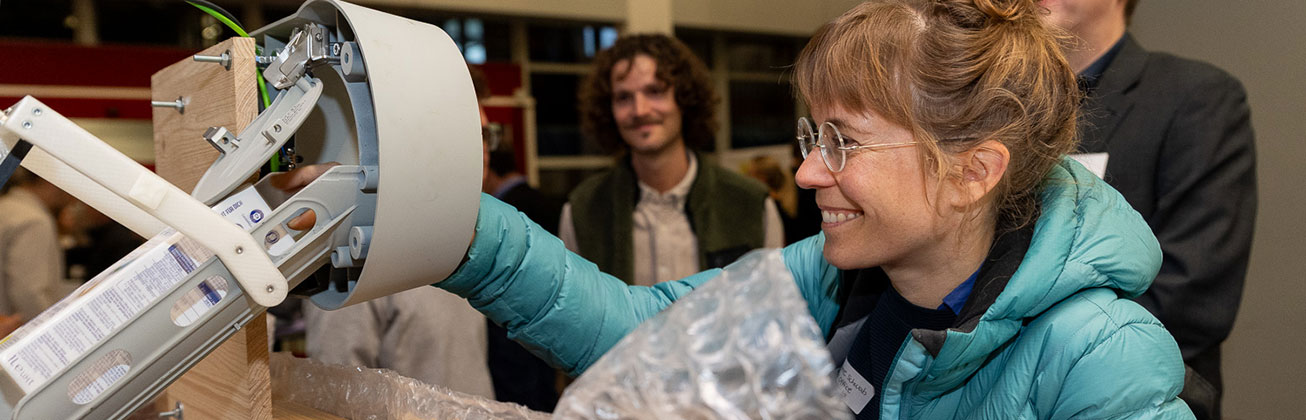 Eine junge Frau tested ein intelligentes Recyclingsystem für Plastik