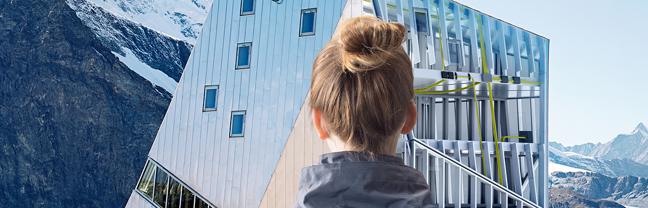 Frau schaut auf Berghütte