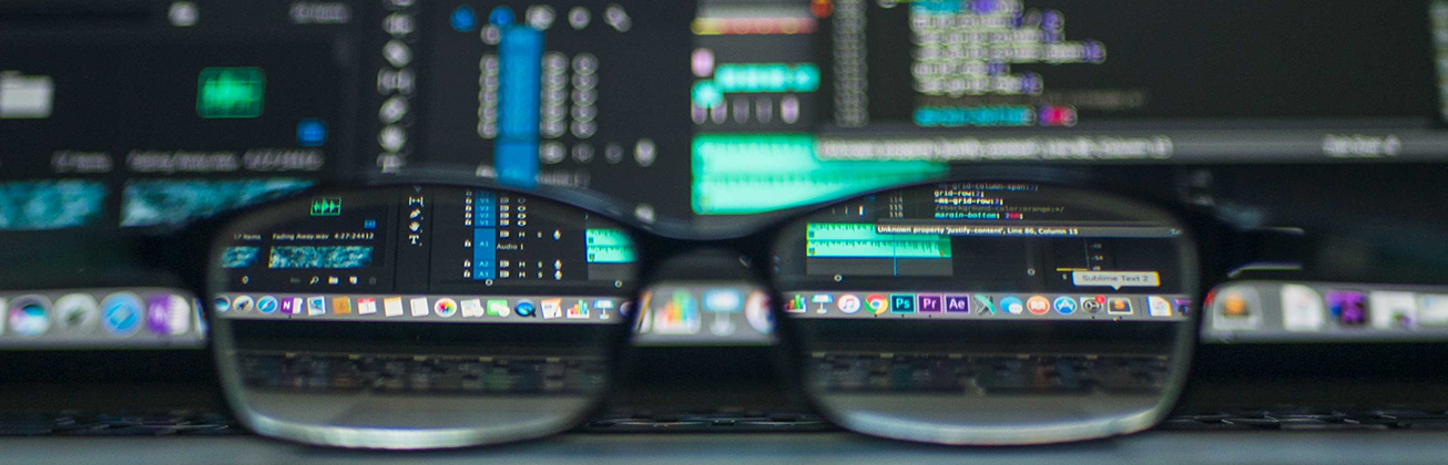 Computer Bildschirm im Hintergrund, Brille im Vordergrund