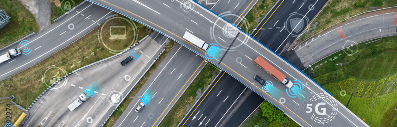 Drohnenaufnahme einer Autobahnkreuzung mit fahrenden Lkw und Pkw, überlagert mit Symbolen für digitale Vernetzung.