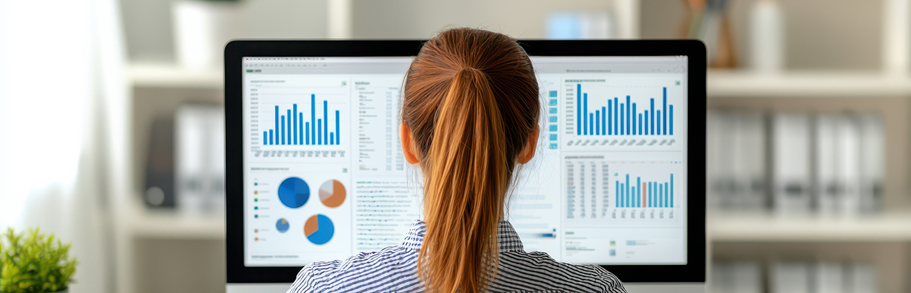 Frau betrachtet am Computer verschiedene Diagramme und Datenvisualisierungen.