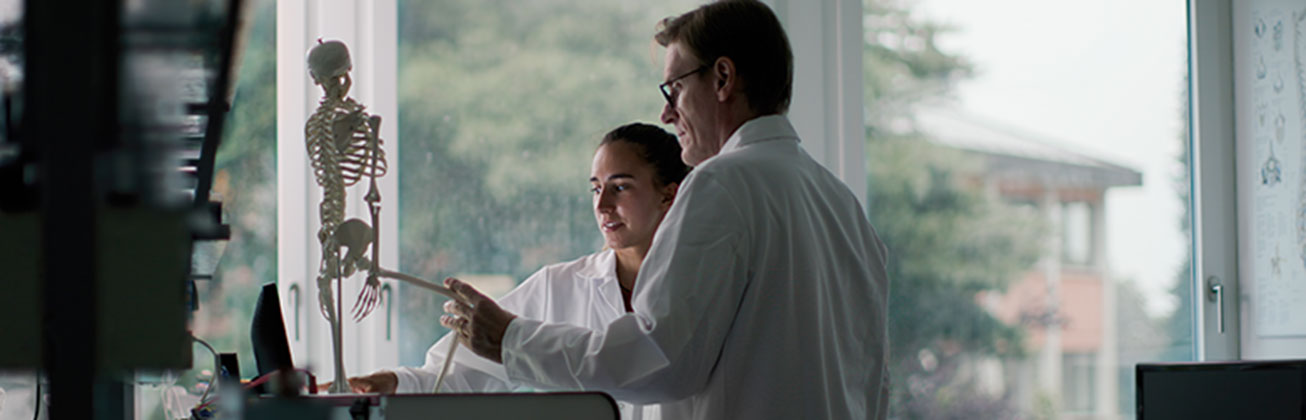 Zwei Personen zeigen auf Skelett