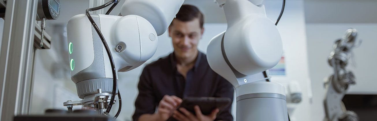 Mann arbeitet an Roboter