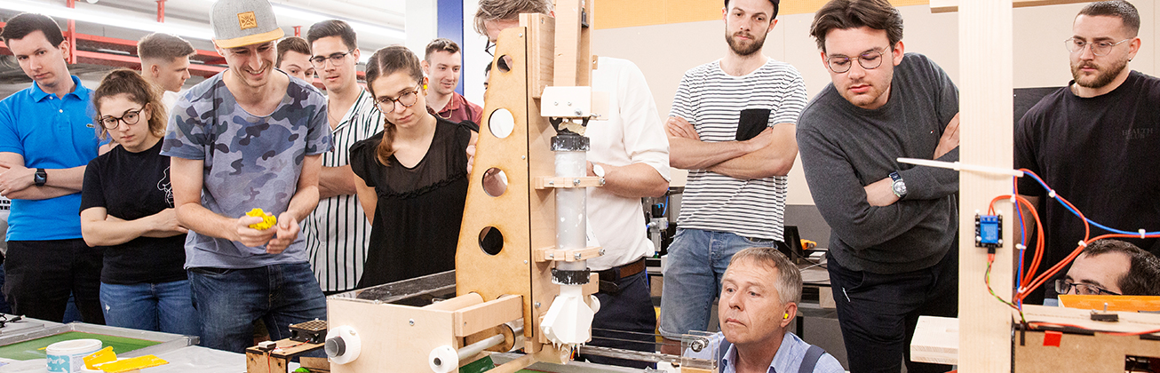 Studierende begutachten die Demonstration einer Maschine