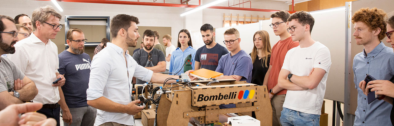 Einer Gruppe von Studierenden wir der Prototyp eines Projekts für die automatisierte Aufbereitung von Gerüstbauteilen vorgestellt.