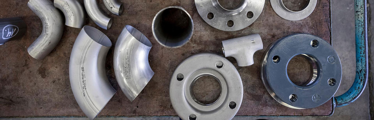 Rohrabschnitte und Verbindungsstücke aus Stahl auf einem Tisch angeordnet