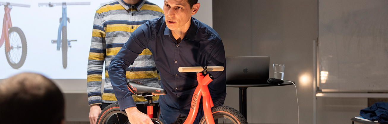 mann mit orangem kinderfahrrad