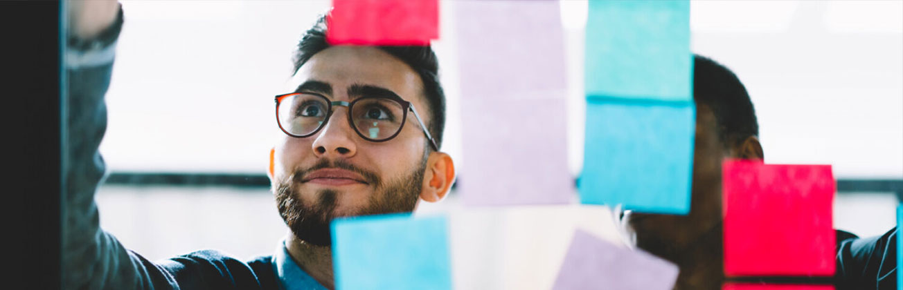 Studierende vor einer Glaswand mit Post-its