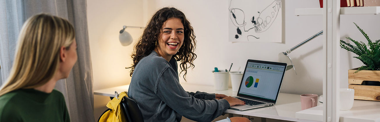 Zwei lachende Studentinnen in WG-Zimmer HSLU