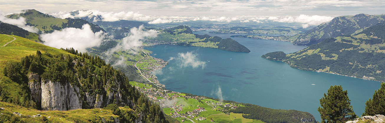 Blick auf Vierwaldstättersee von einem Berg aus, Bergketten im Hintergrund sichtbar, Wolkengebilde am Himmel