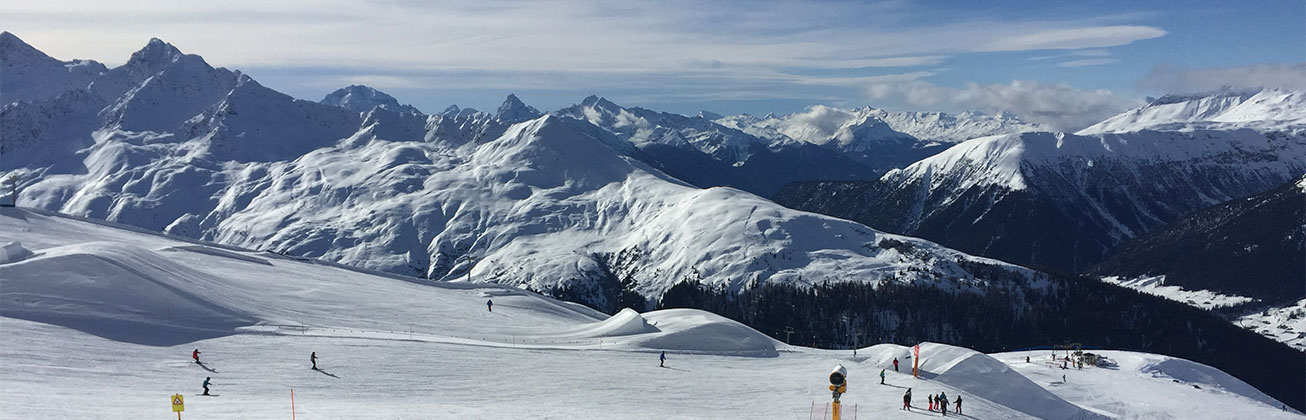 Skigebiet, im Hintergrund verschneite Berge