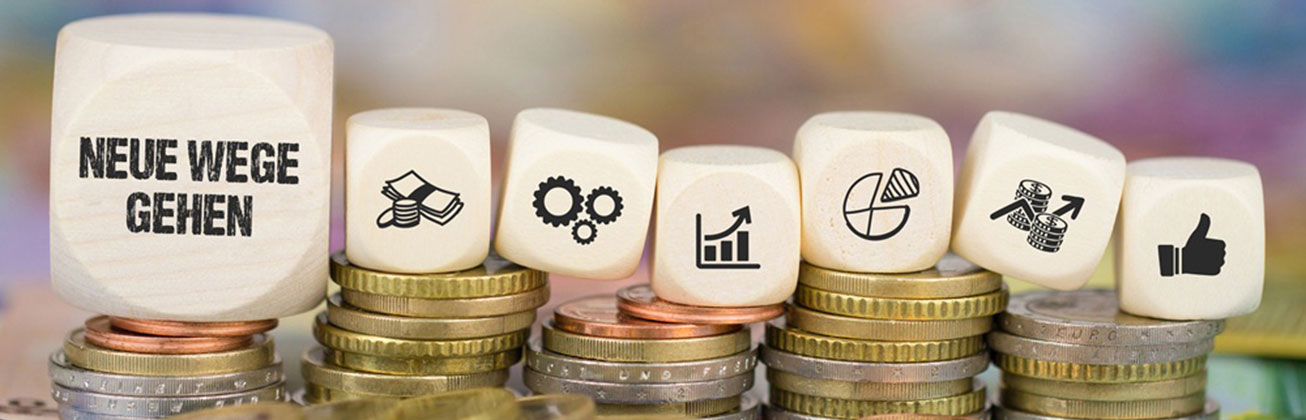 Würfel auf Geldmünzen mit Aussage Neue Wege gehen