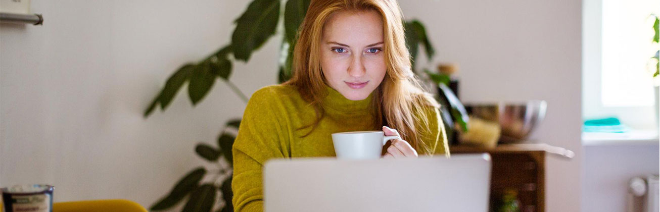 Junge Frau schaut auf Laptop