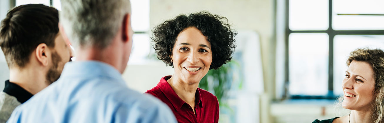 Zwei Frauen und zwei Männer stehen zusammen und reden zusammen