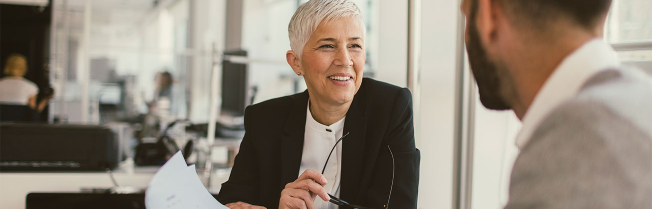 Eine Frau ist im Gespraech mit einem klienten