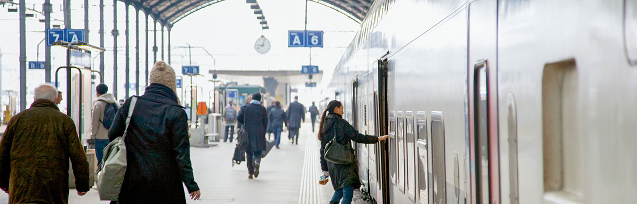 Bahnhofperron Menschen steigen in den Zug ein