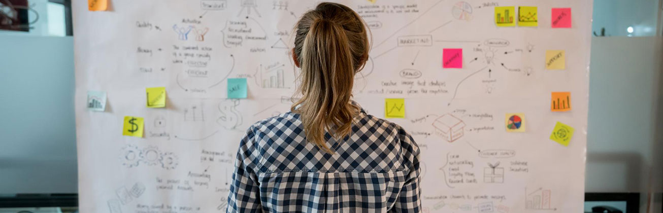 Frau steht vor Ideenwand