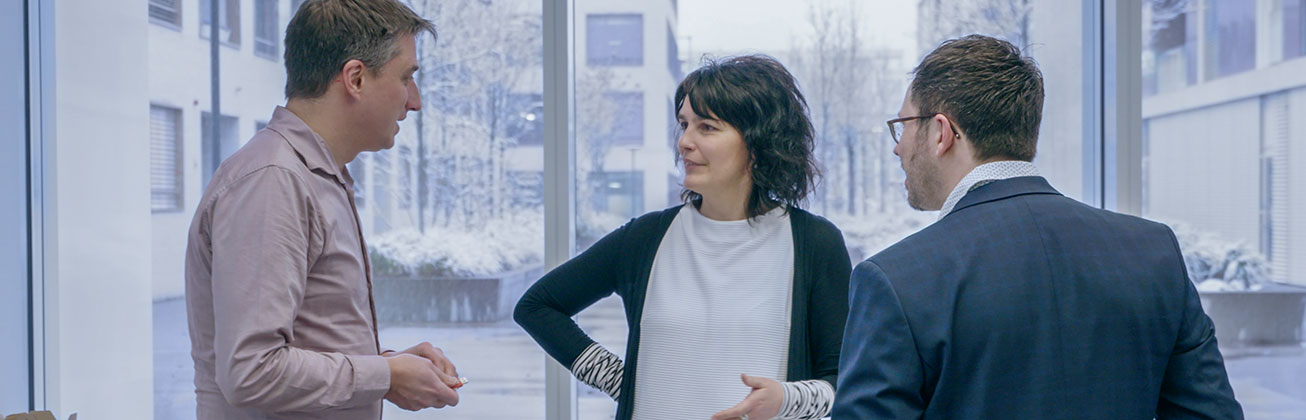 A woman and two men engaged in discussion