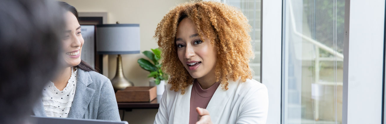 Zwei Frauen unterhalten sich in einem Besprechungsraum