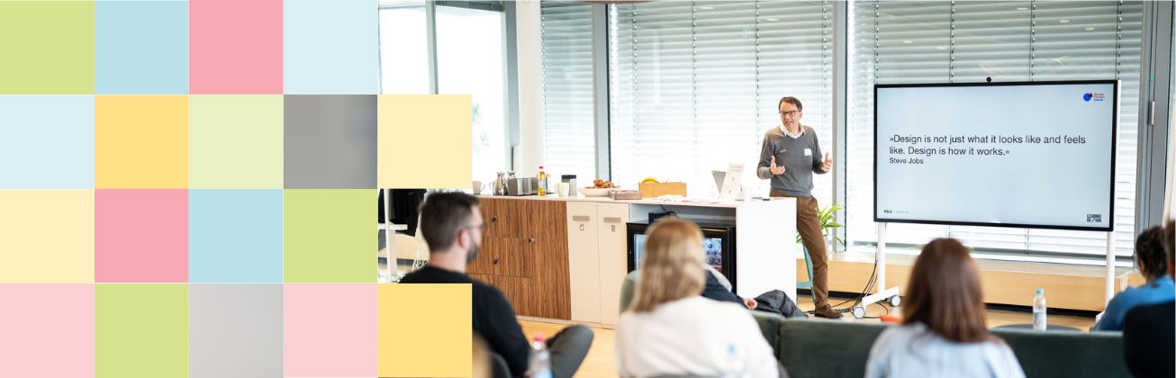 Mehrere Personen verfolgen einen Vortrag zum Thema Design Faehigkeit