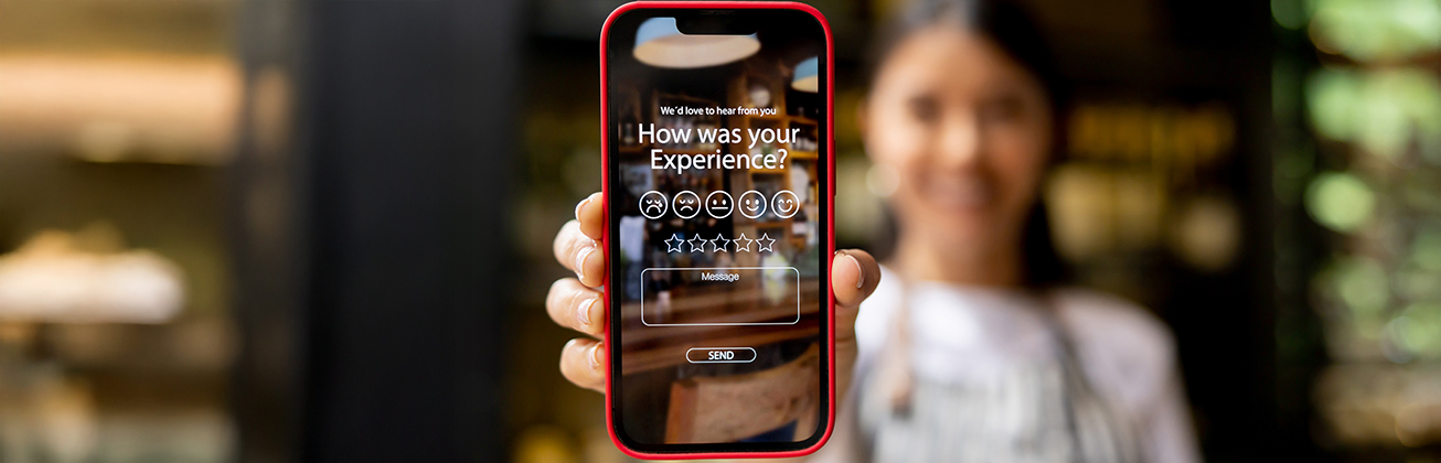 Kellnerin oder Gast zeigt App um Restaurant Erfahrung zu bewerten