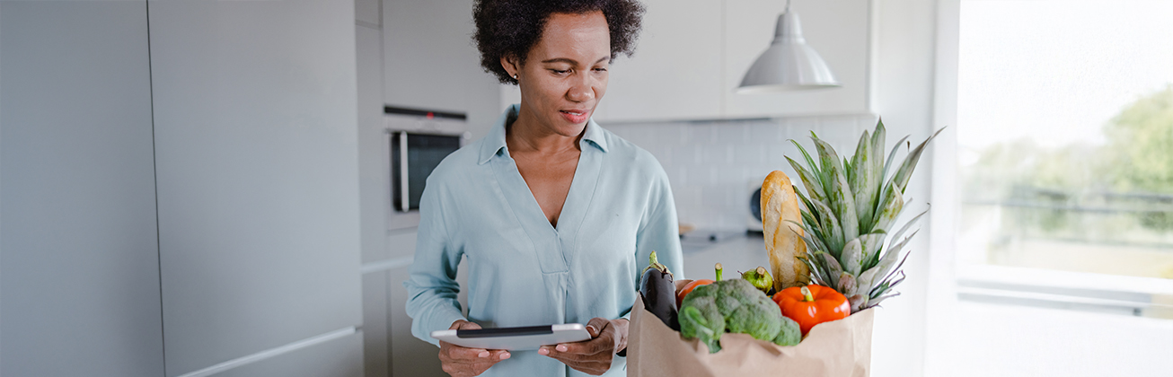 Frau prueft ihre Einkäufe mittel Tablet