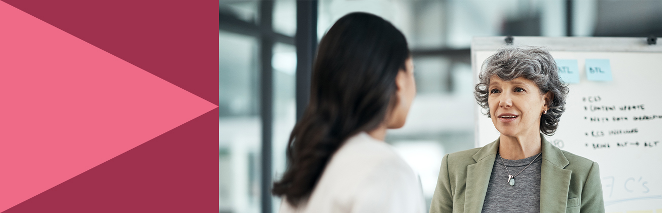 Zwei Personen im professionellen Austausch vor einem Whiteboard mit Notizen – Symbolbild für strategische Kommunikationsplanung, Führungskompetenz und effektives Stakeholder-Management.
