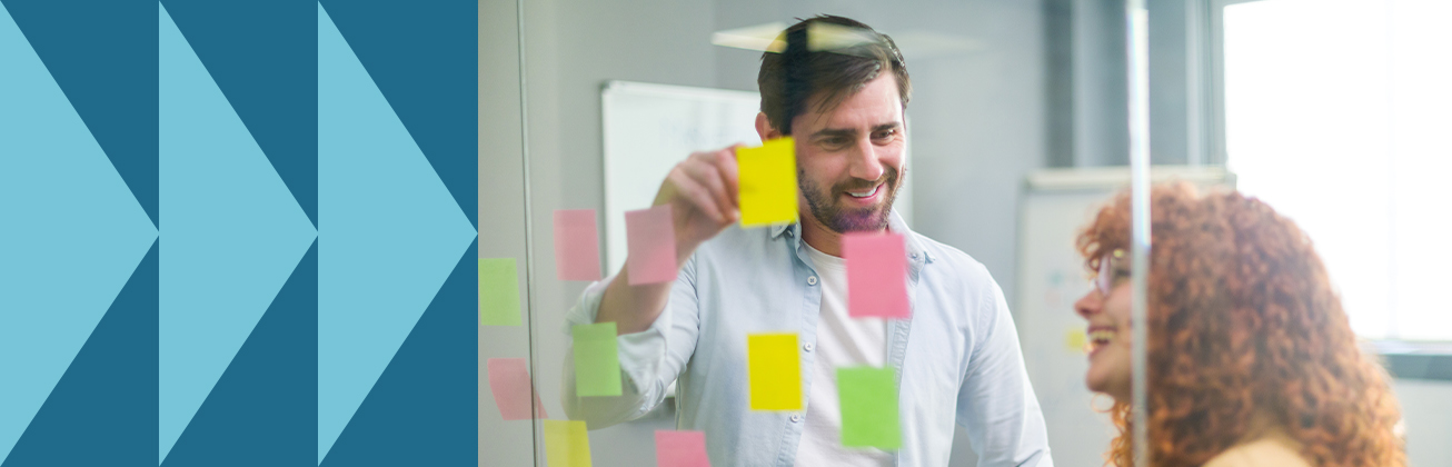 Team plant UX-Projekt mit farbigen Sticky Notes an Glaswand – kollaborative Arbeitsweise im User Experience Design.