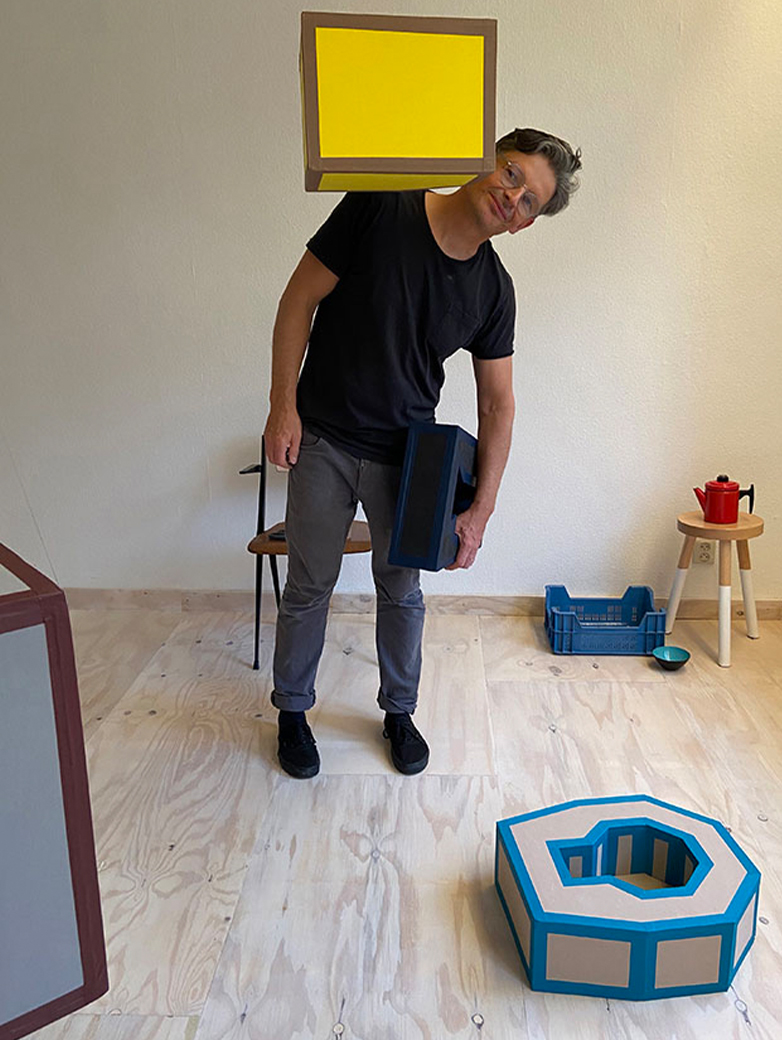 Ein Mann mit verschiedenen Gegenständen im Raum. 